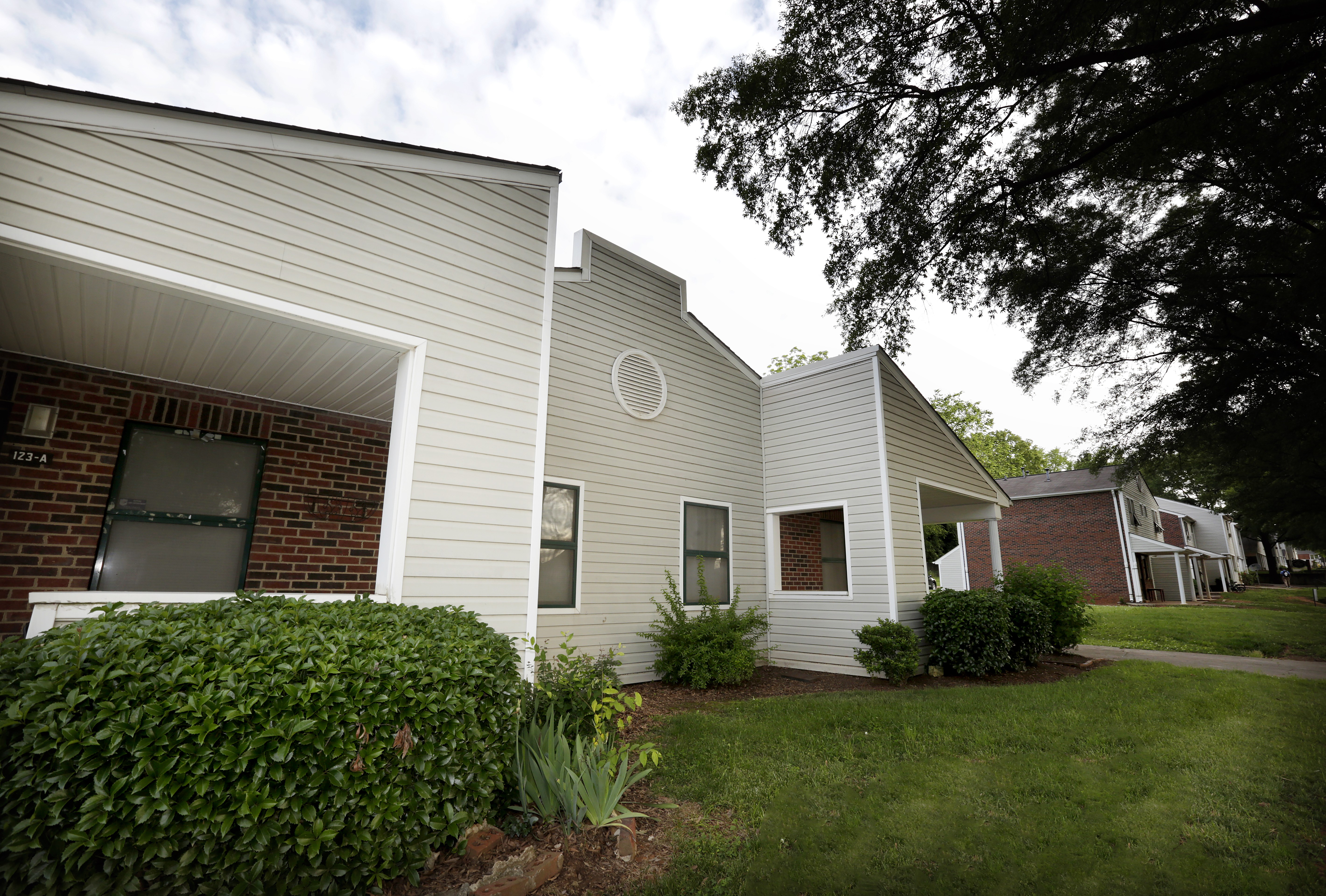 A house with a white siding and a brick chimney.